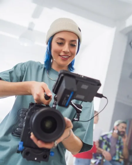 Operadora prepara una cámara de cine en un estudio luminoso